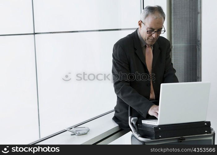 Businessman using a laptop in the waiting room of an airport