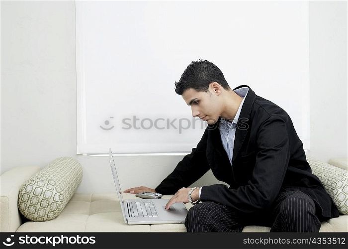 Businessman using a laptop on a couch