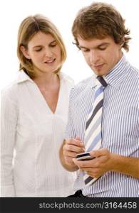 Businessman using a personal data assistant with a businesswoman standing beside him