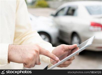 Businessman using a smartphone for taking a photo to send to insurance. Concept of claim insurance for a car accident online after send photo and evidence to the insurance company