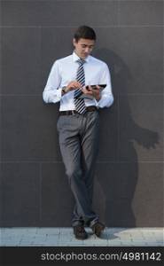 Businessman using a tablet pc outdoors