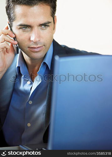 Businessman Using Cell Phone and Laptop