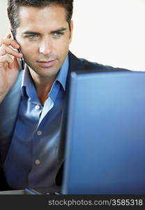 Businessman Using Cell Phone and Laptop