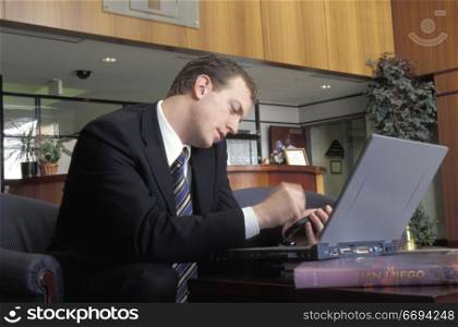 Businessman Using Cell Phone and Laptop
