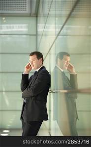 Businessman Using Cell Phone in Office Corridor