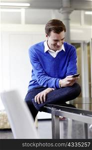 Businessman using cell phone on desk