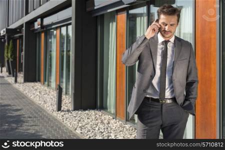 Businessman using cell phone outside office