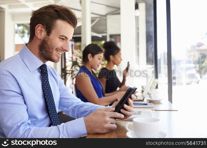 Businessman Using Digital Tablet In Coffee Shop