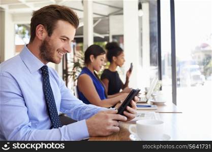 Businessman Using Digital Tablet In Coffee Shop