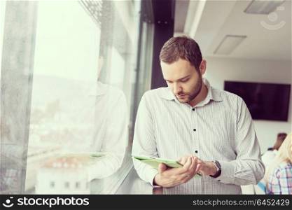 Businessman Using Digital Tablet in corporate office by window
