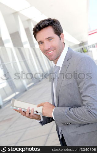 Businessman using electronic tablet outside a building