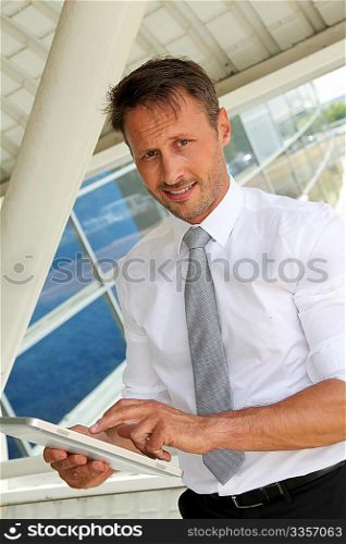 Businessman using electronic tablet outside the airport