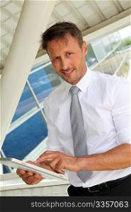 Businessman using electronic tablet outside the airport