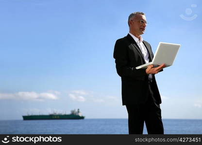 Businessman using his laptop by the water&acute;s edge