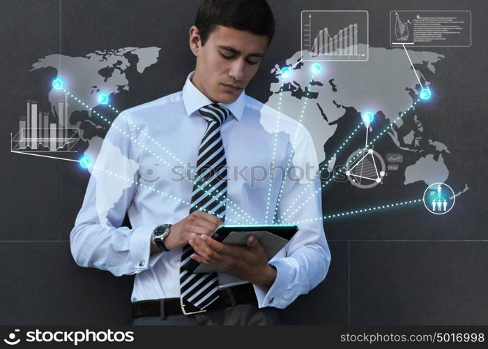 Businessman using his tablet computer outdoors near office building