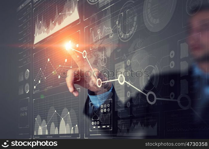 Businessman using innovative technologies. Close up of businessman touching virtual panel with finger