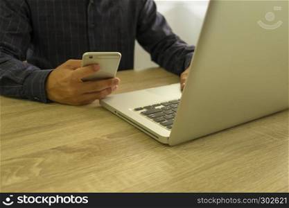 Businessman using laptop and mobile phone to the situation on the market value , Business concept