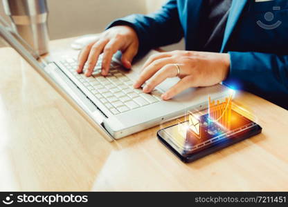 businessman using laptop and smartphone screen display and technology advances in communications for business. The hologram concept of advancement in living in the future.