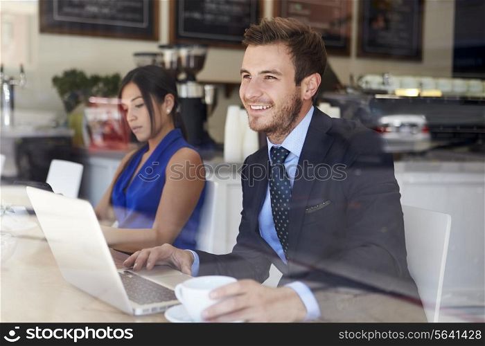 Businessman Using Laptop In Coffee Shop