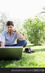 Businessman Using Laptop in Park
