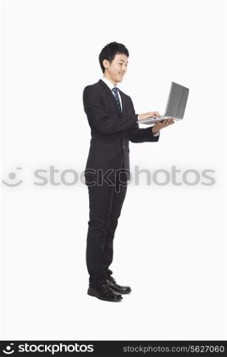 Businessman using laptop while standing