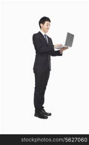 Businessman using laptop while standing
