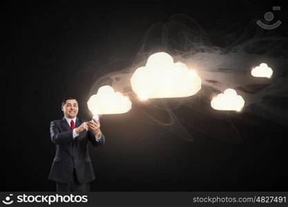 Businessman using mobile application. Businessman using his smartphone and cloud computing concept