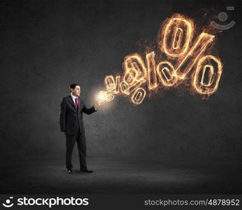 Businessman using mobile application. Businessman using his smartphone and glowing percent sign of screen