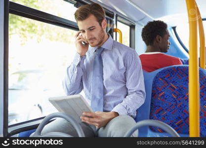 Businessman Using Mobile Phone And Digital Tablet On Bus