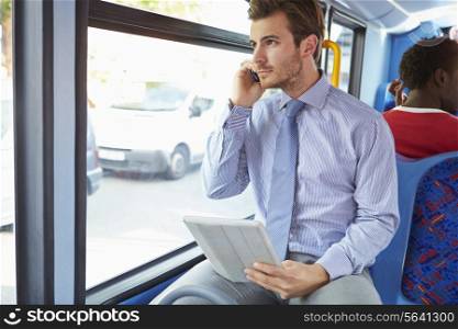 Businessman Using Mobile Phone And Digital Tablet On Bus