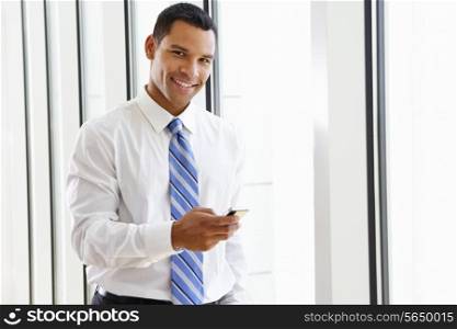 Businessman Using Mobile Phone In Office