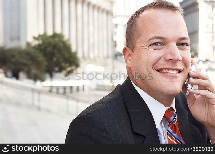 Businessman using mobile phone outdoors portrait