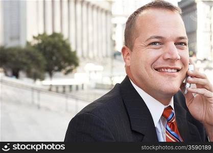 Businessman using mobile phone outdoors portrait