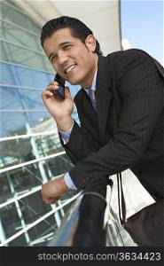 Businessman using mobile phone outside office building