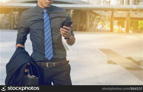 Businessman using mobile phone with city background