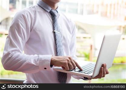 businessman using modern laptop for working at personal space outdoor, wireless connection internet on his notebook computer.