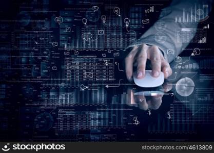 Businessman using mouse. Hand of businessman in suit on dark digital background using wireless computer mouse