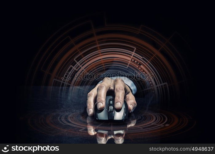 Businessman using mouse. Hand of businessman in suit on dark digital background using wireless computer mouse