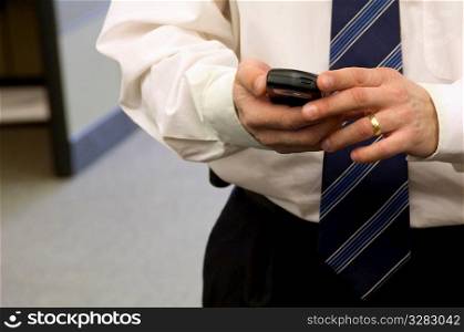 Businessman using PDA in office.