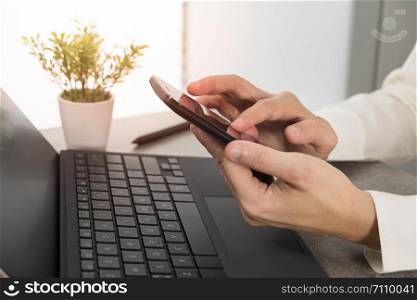 businessman using smartphone and laptop in office.
