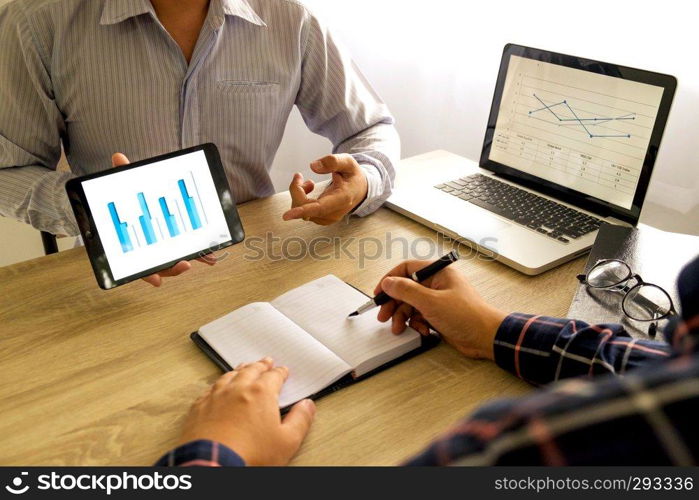 Businessman using tablet to teach and  analysis the situation on the market value , Business concept