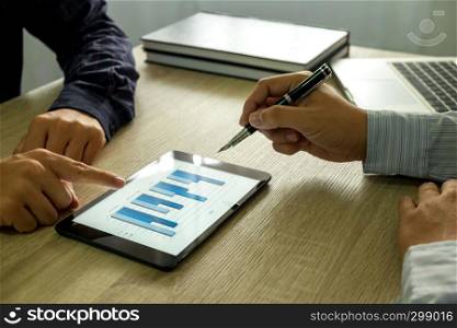 Businessman using tablet to teach and analysis the situation on the market value , Business concept