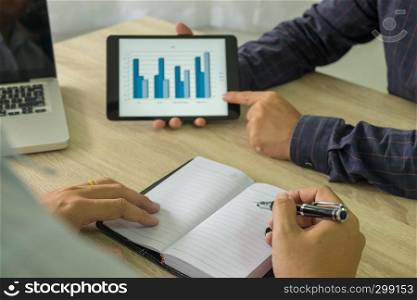 Businessman using tablet to teach and analysis the situation on the market value , Business concept