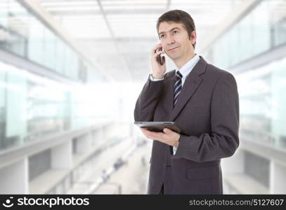 businessman using touch pad of tablet pc, on the phone, at the office