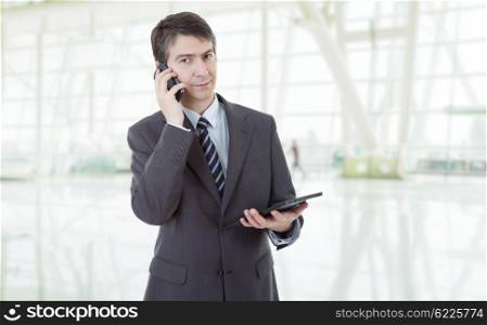 businessman using touch pad of tablet pc, on the phone, at the office