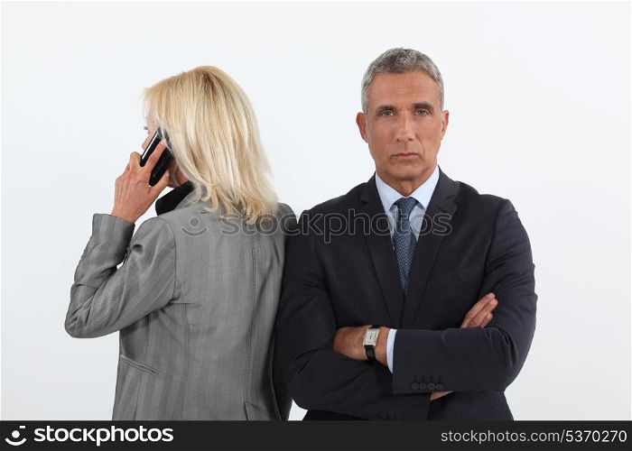 businessman waiting while his colleague is talking on her cell