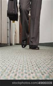 Businessman walking along corridor