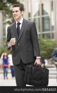 Businessman Walking Along Street Holding Takeaway Coffee