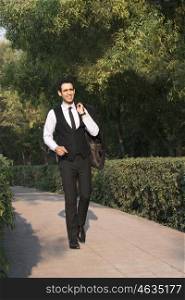 Businessman walking in a park , INDIA , DELHI