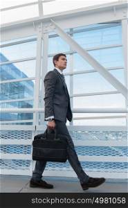 Businessman walking in urban environment of airport or office building
